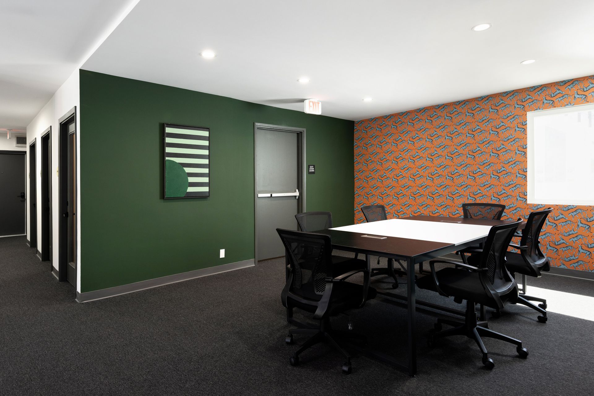 A meeting room with a table, chairs, and decorated walls.