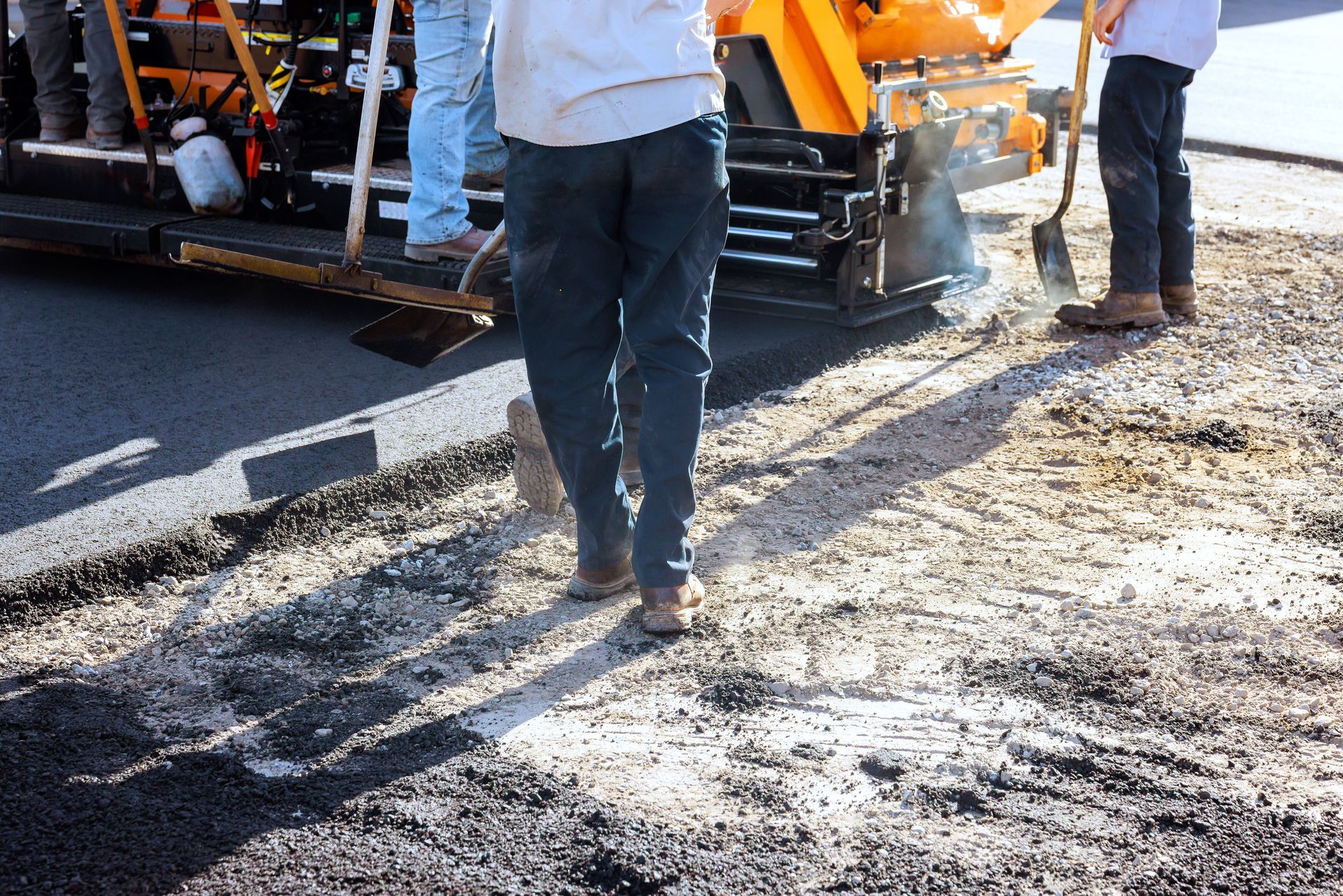 A professional team providing commercial paving services by laying fresh asphalt on a road. A professional team providing commercial paving services by laying fresh asphalt on a road.