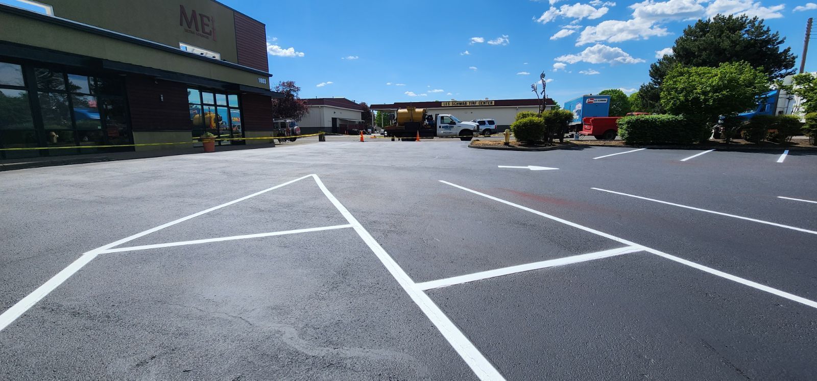 Parking lot with fresh white lines and a building under a blue sky.