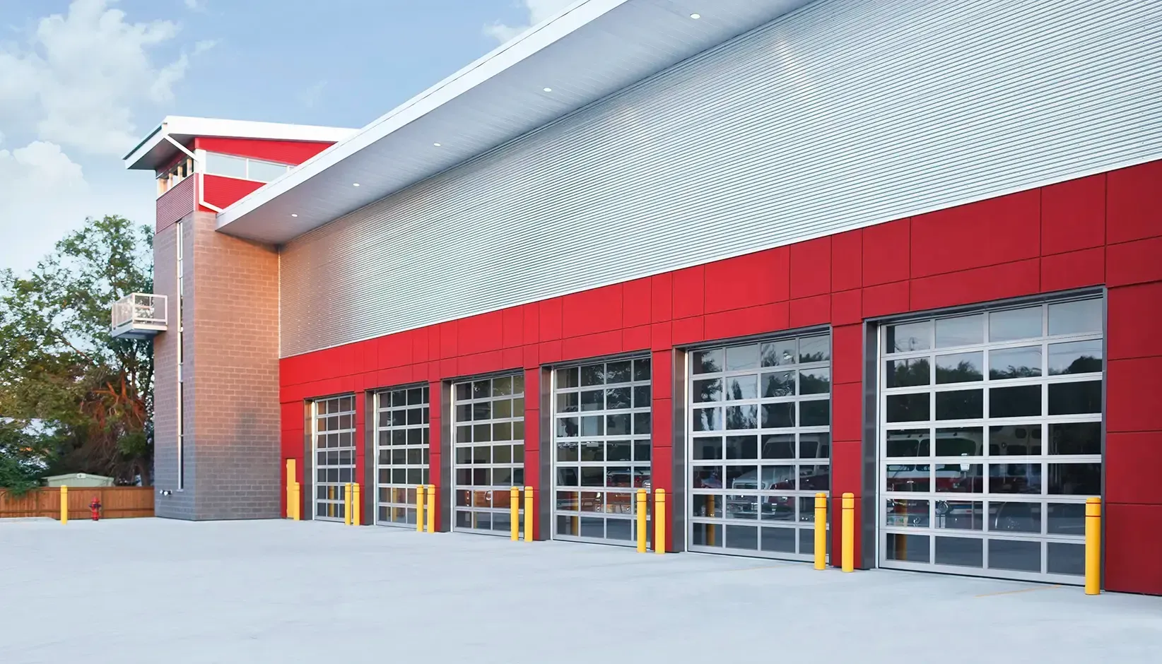 Row of white garage doors with red trim on a building exterior