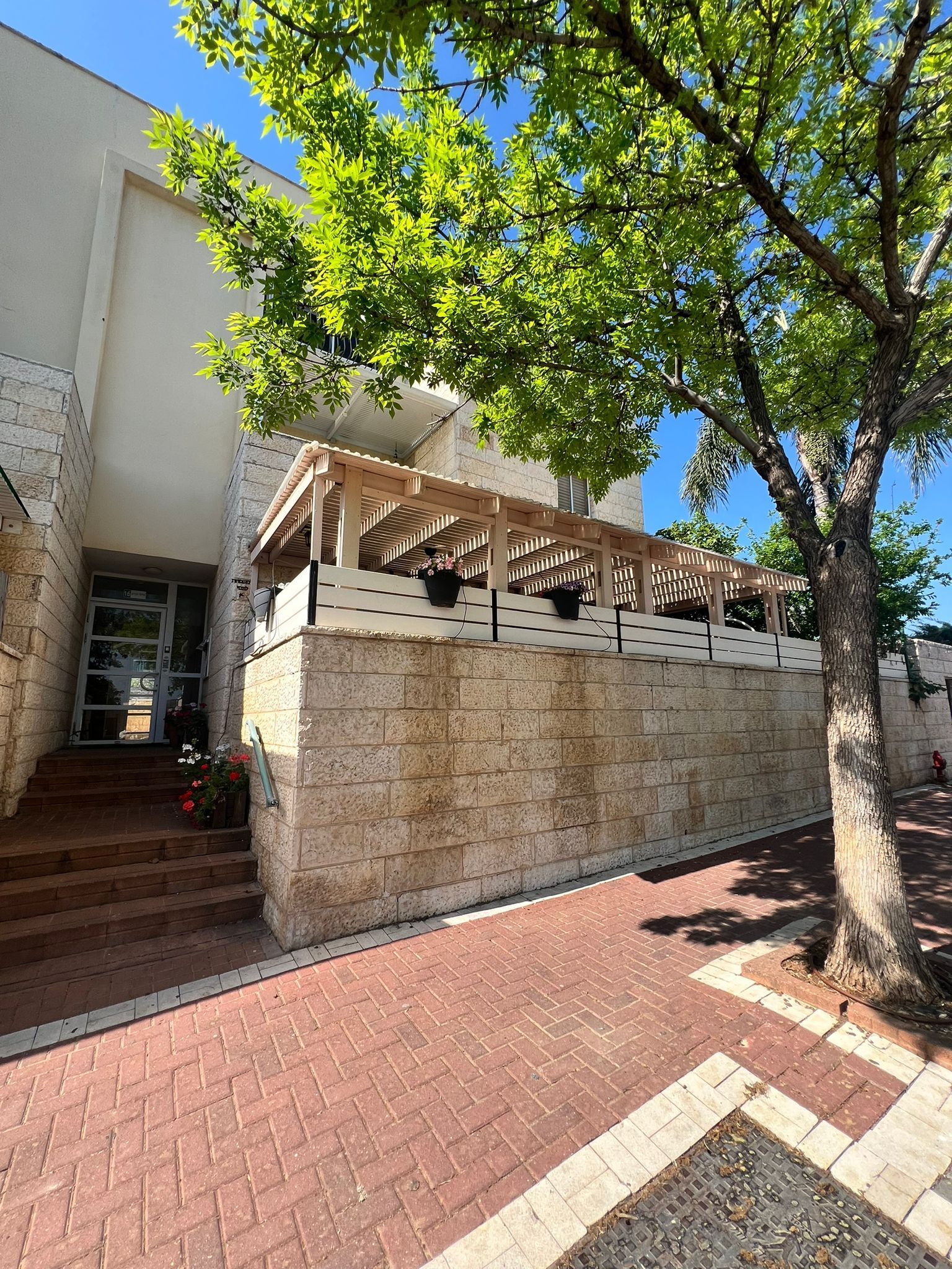 בניין לבן גדול עם מדרגות המובילות אליו ועצים בחזיתו.
