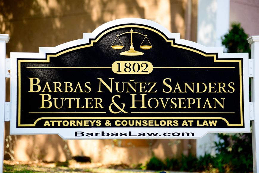 Black-and-gold law firm sign reading
