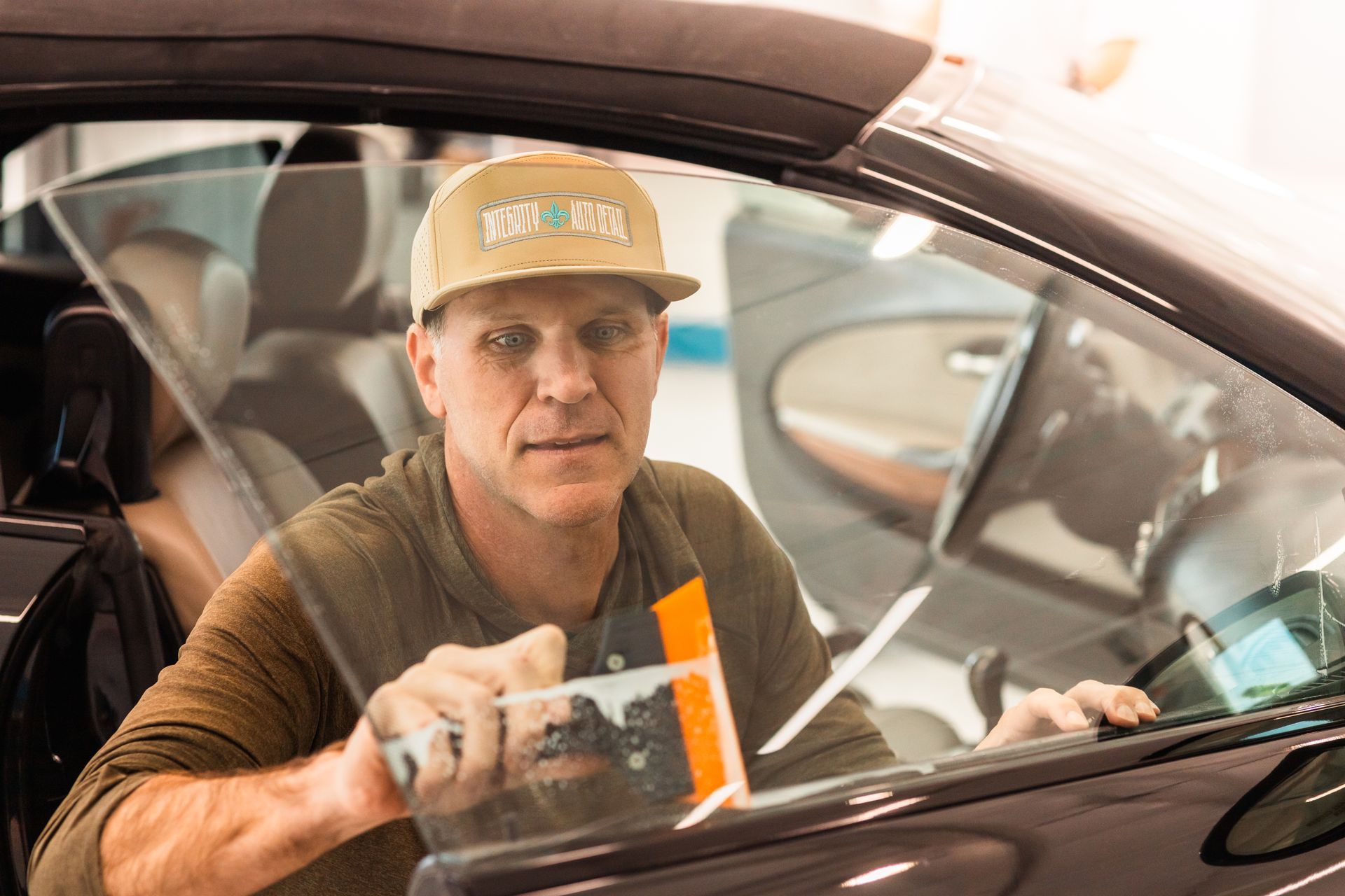 A person is applying window tinting to a car window.