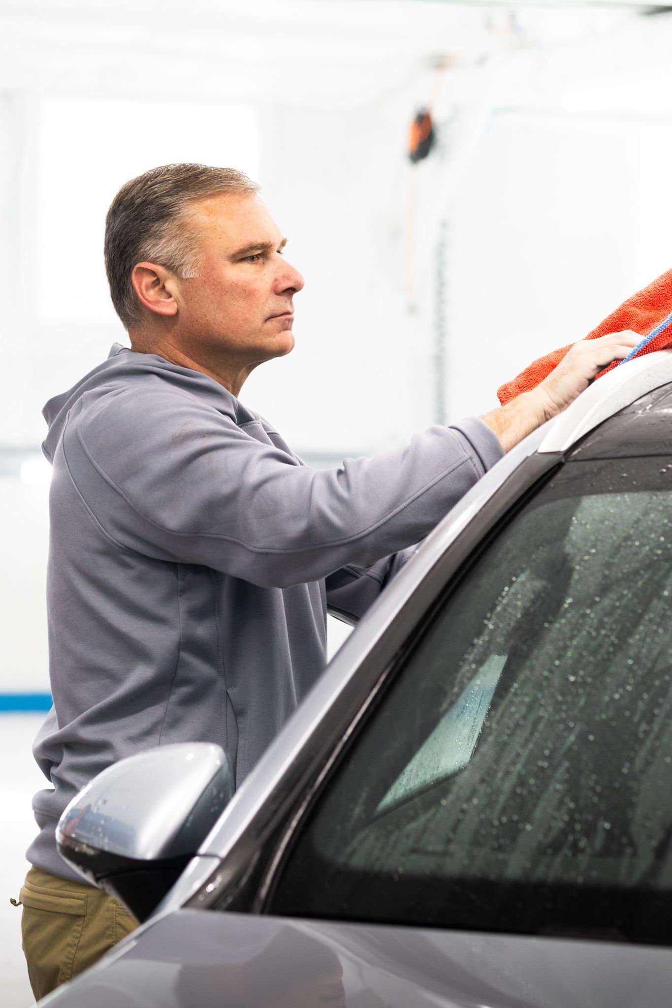 Detailer hand-drying a car after wash at Integrity Auto Detail, St. Louis