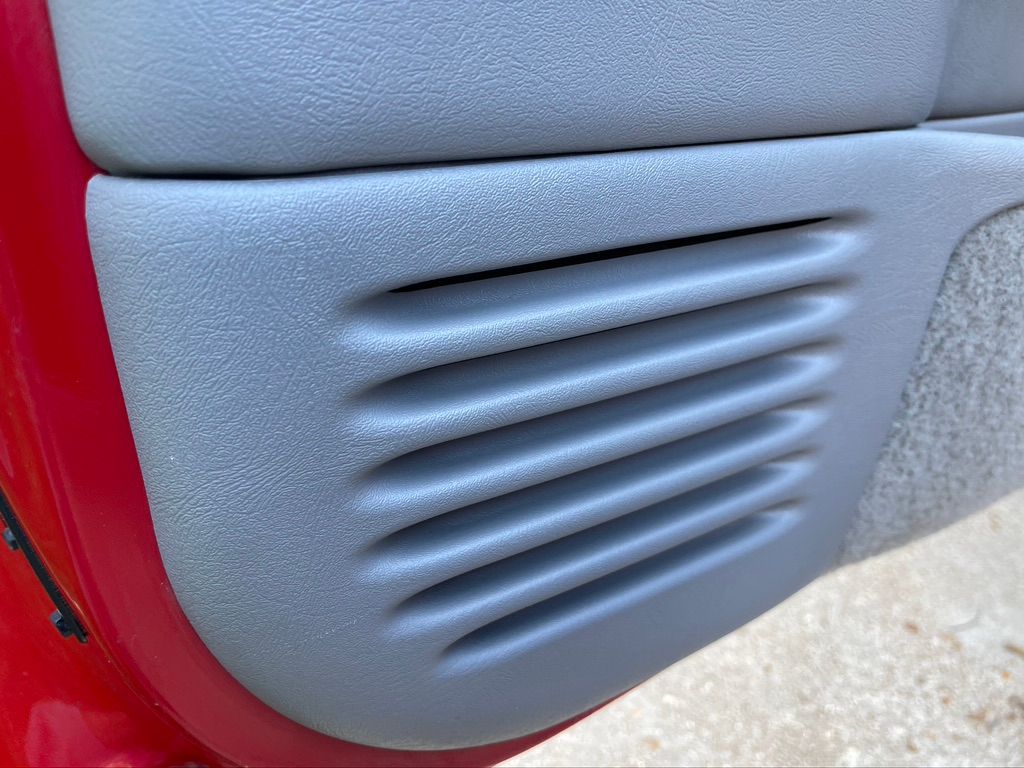A close up of a door panel with a vent on it.