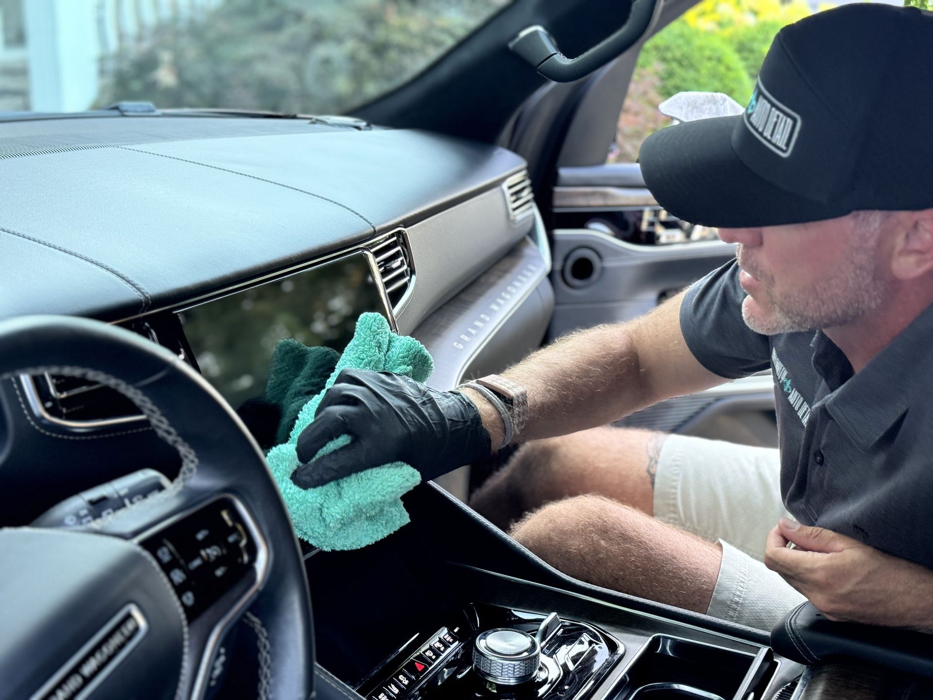 A man is applying a protective film to the hood of a car.