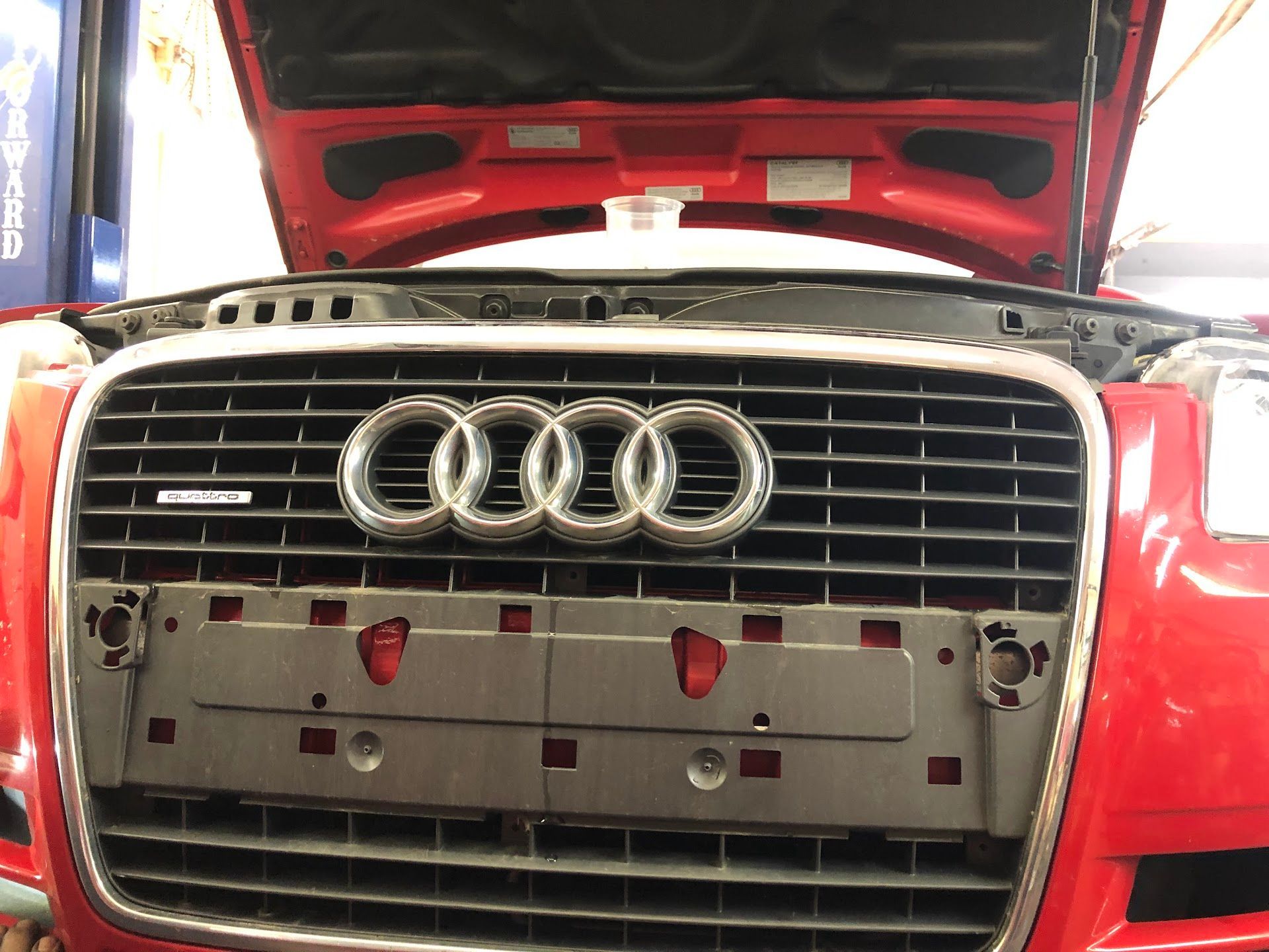 Red Audi with open hood at a mechanic's shop. Grille and emblem are visible. | Rose Brothers Garage