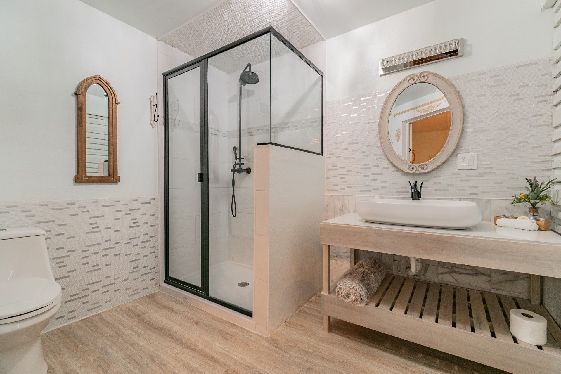 A bathroom with a toilet , sink , mirror and shower.