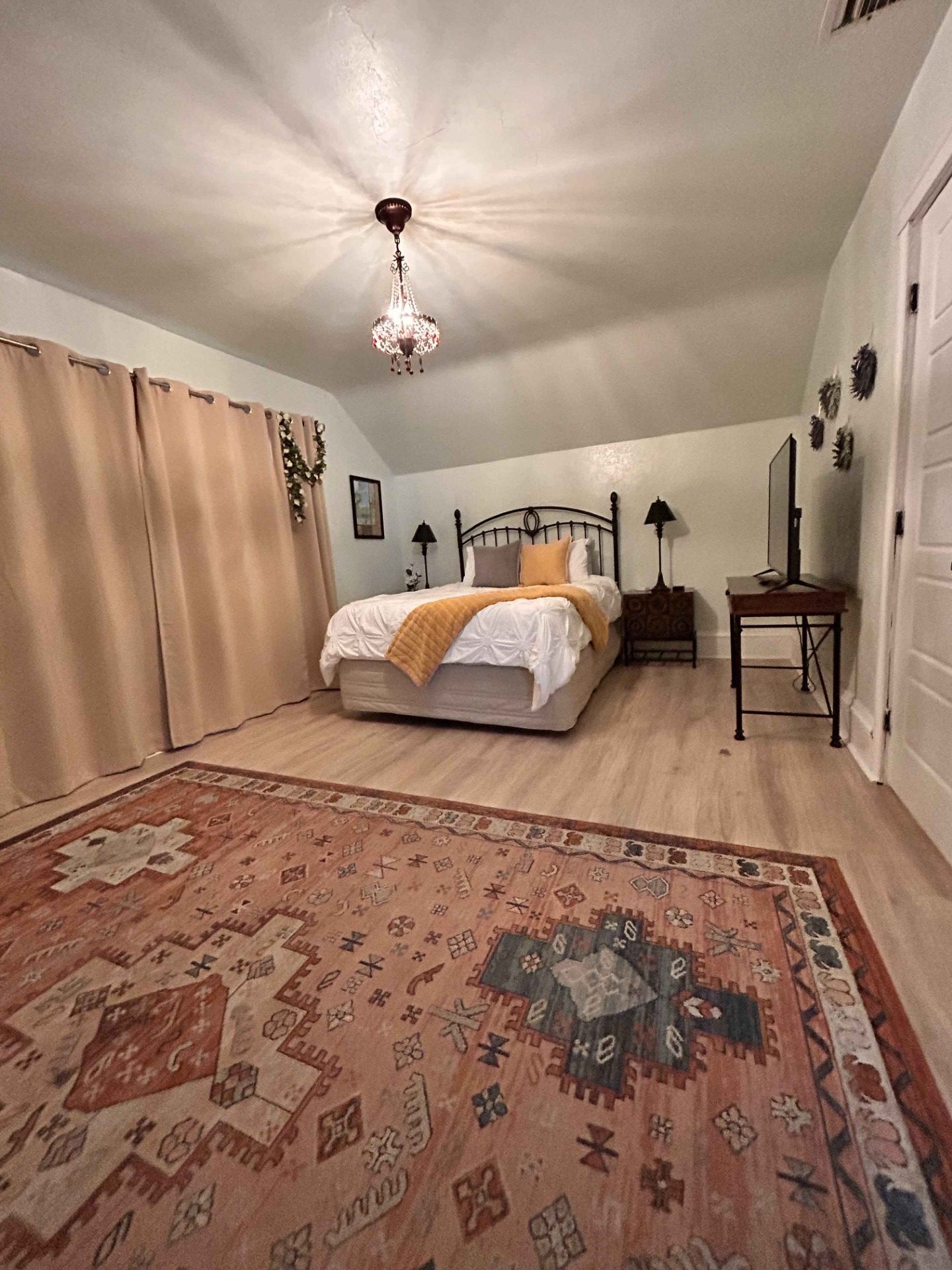 A bedroom with a large bed and a rug.