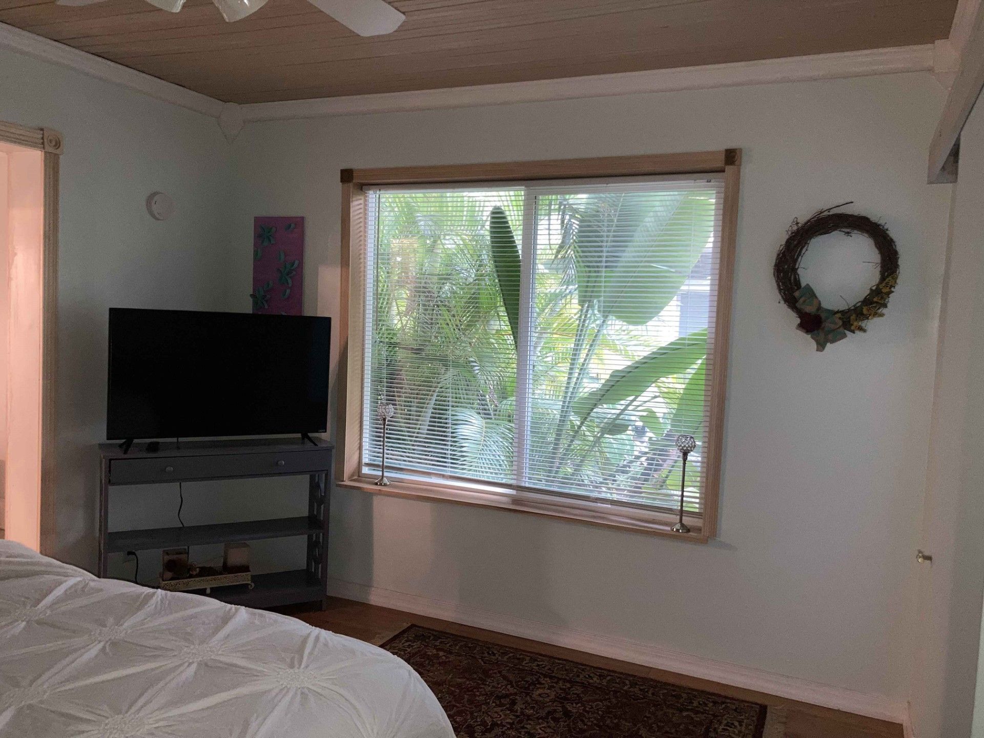 A bedroom with a bed , television , and window.
