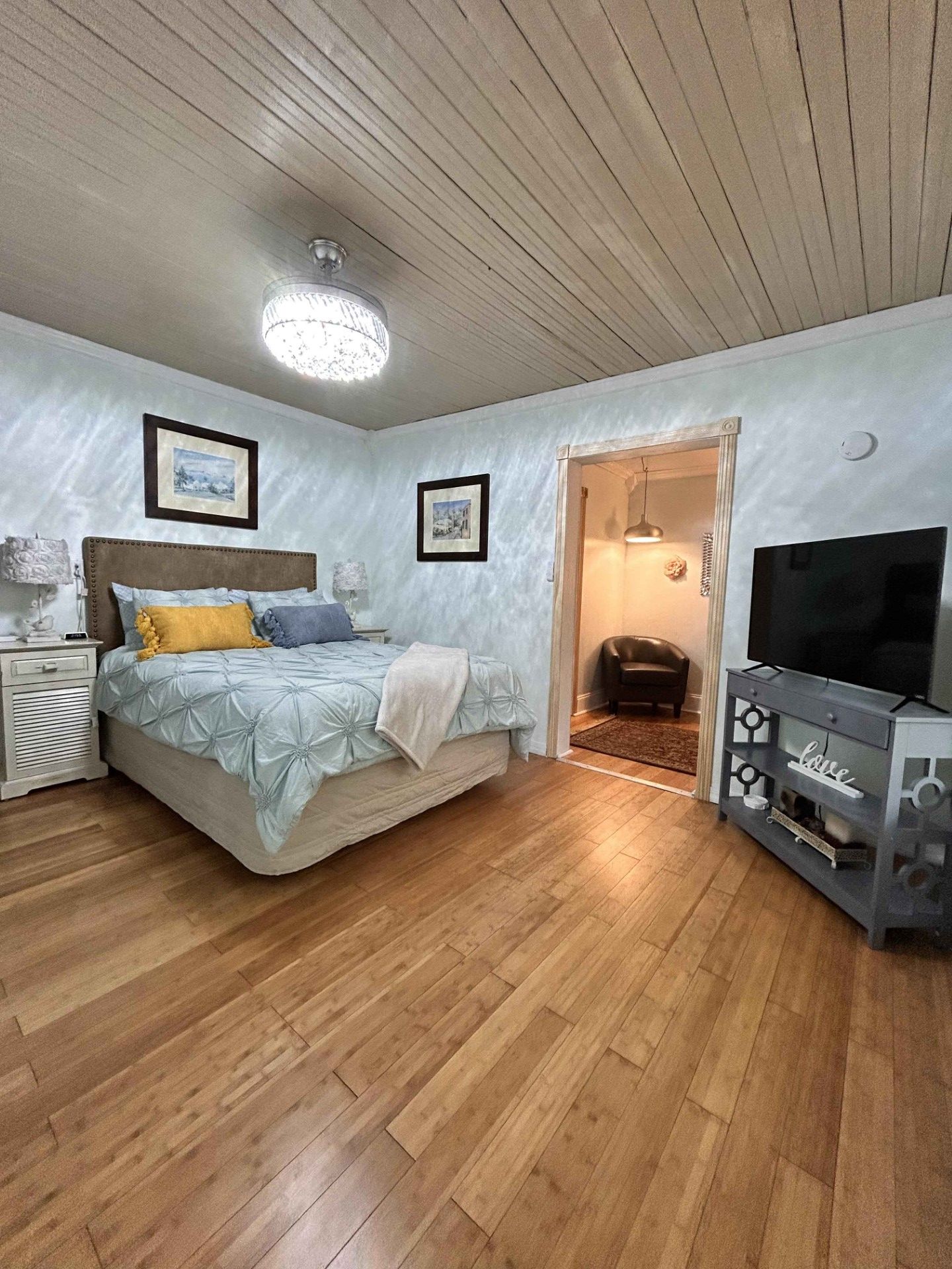 A bedroom with a king size bed and a flat screen tv.
