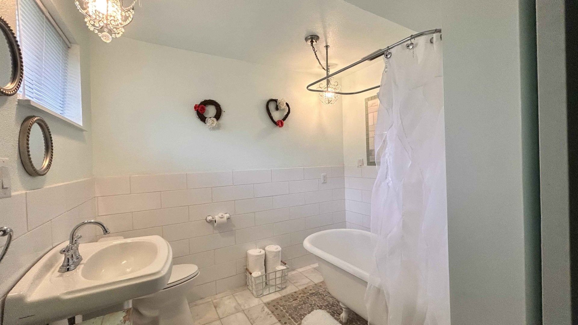 A bathroom with a sink , toilet , shower curtain and mirror.