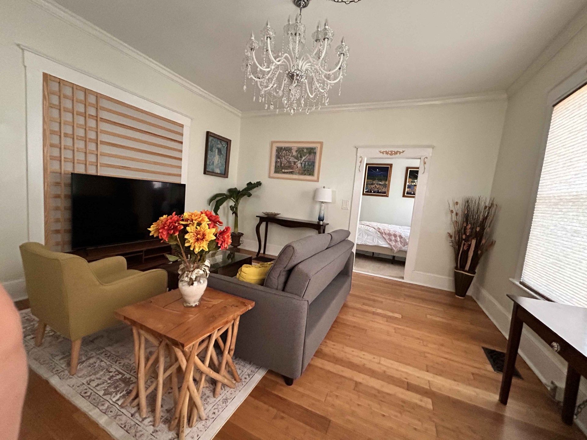 A living room with a couch , chairs , and a flat screen tv.