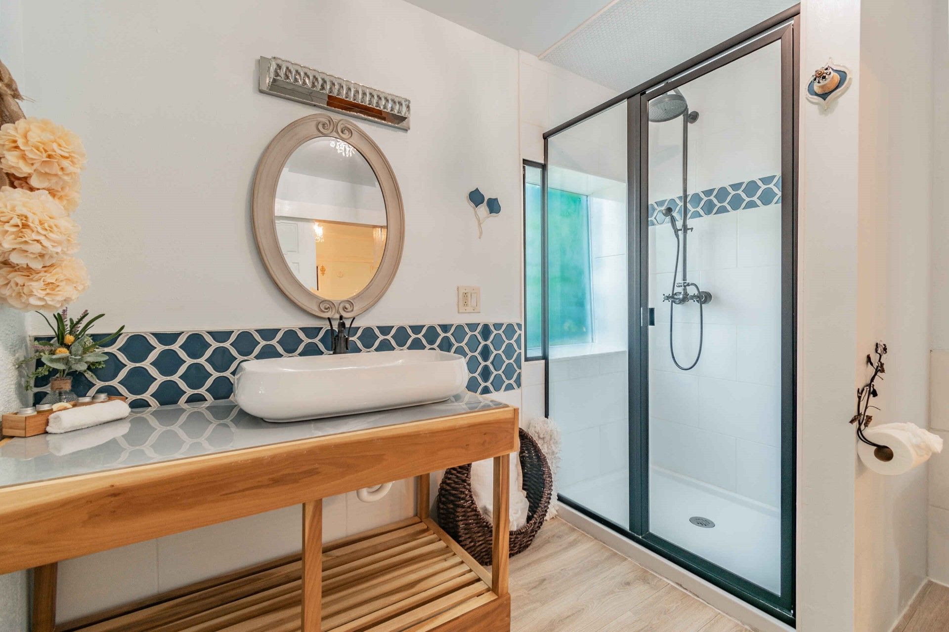 A bathroom with a sink , mirror and shower.