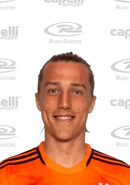 A man in an orange shirt is smiling for the camera