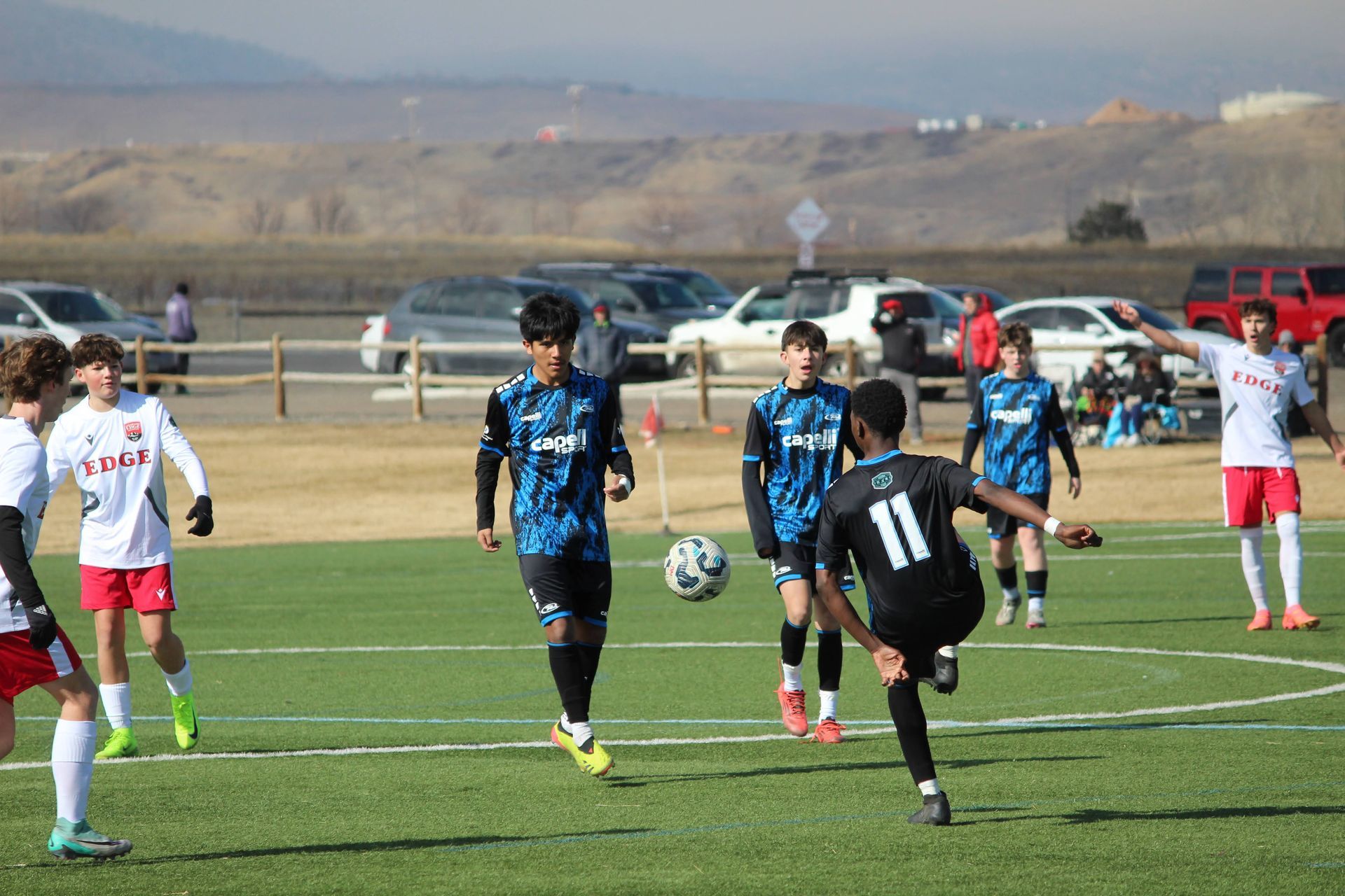 A group of young men are playing soccer on a field.