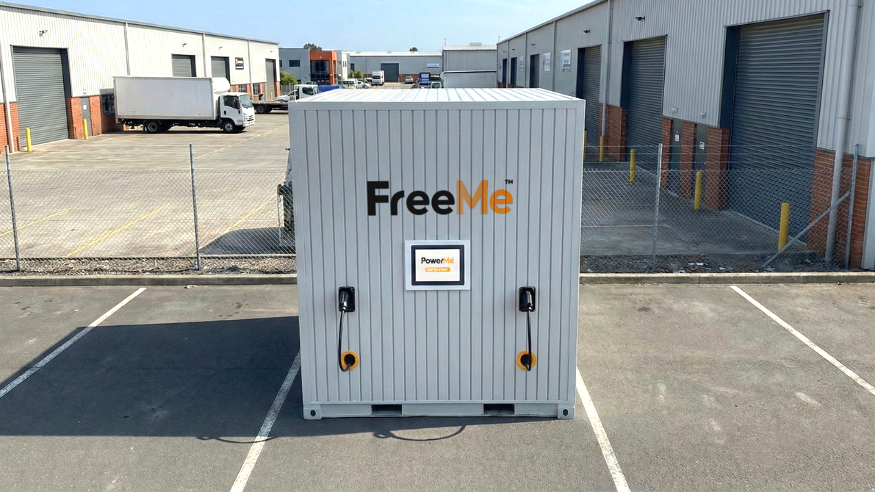 Freestanding groundwork free FreeMe EV Charging container  in an industrial parking lot, with white and gray panels.