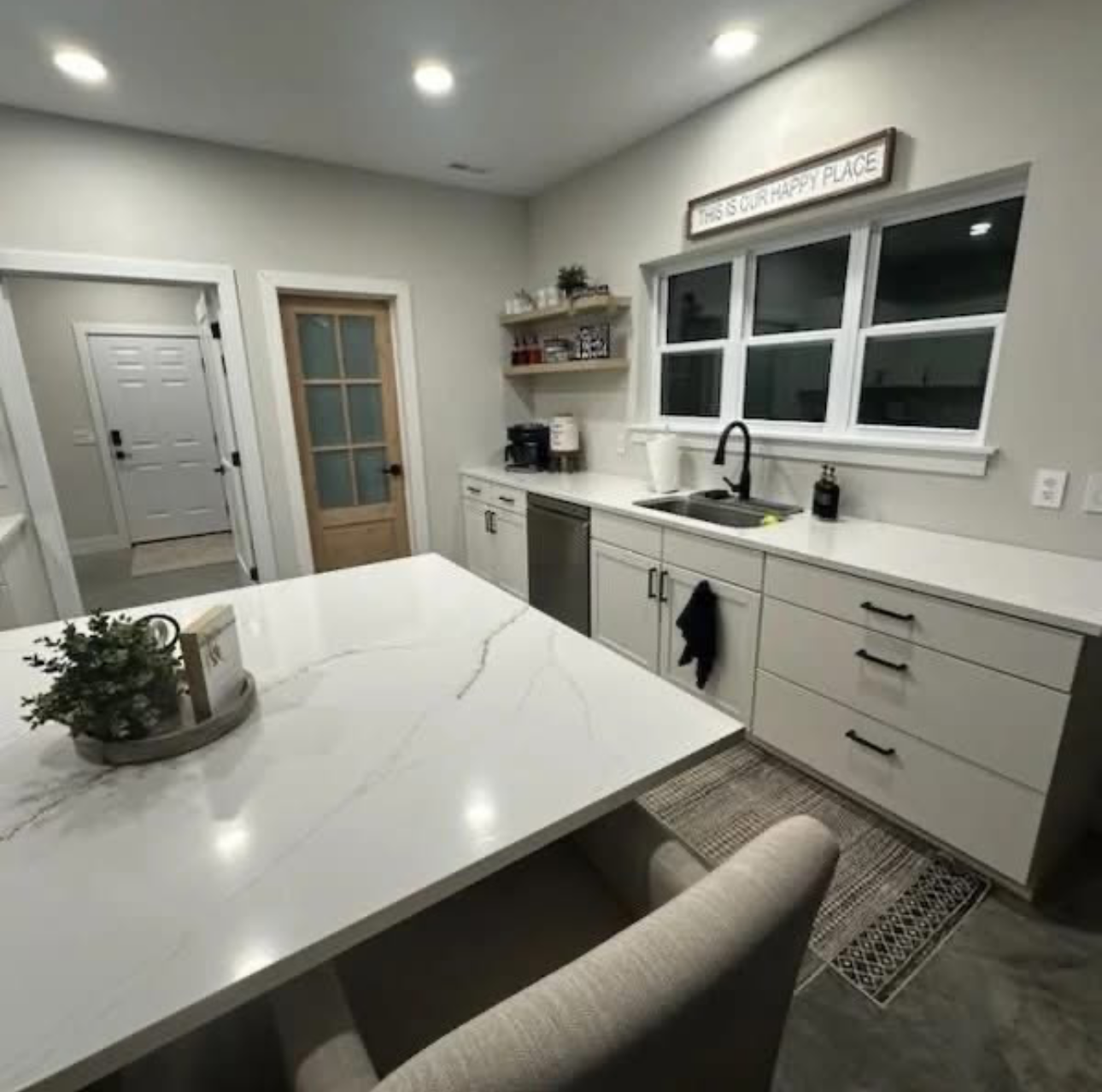 Elegant white kitchen with gold trim cabinets, backsplash, and countertops; built-in stovetop.