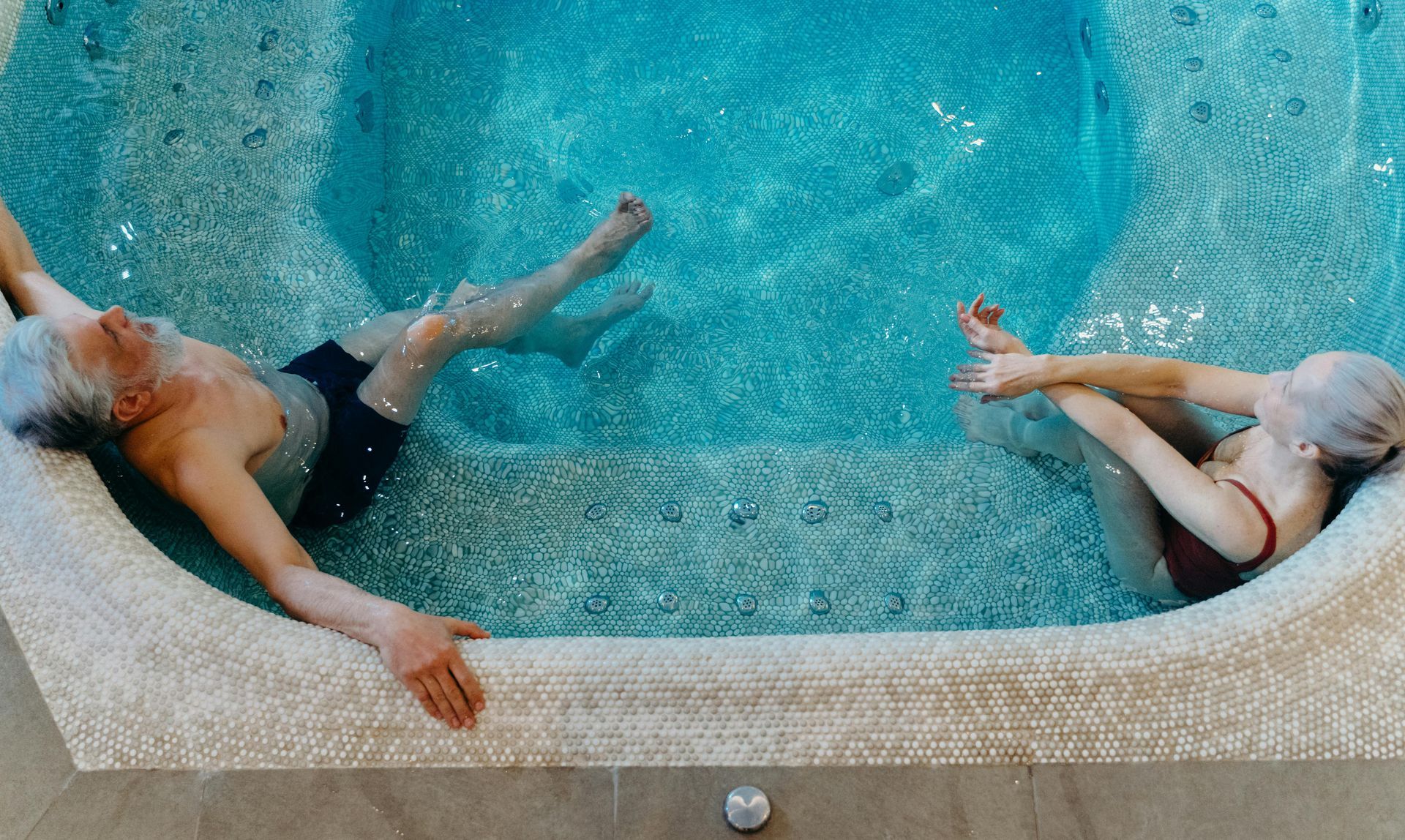 Un uomo e una donna sono sdraiati in una piscina.