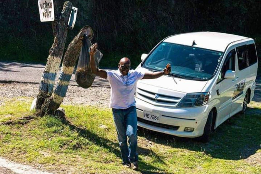 A man is standing in front of a white van