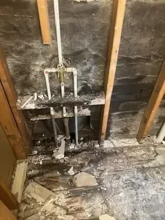 A bathroom with a lot of pipes coming out of the wall.