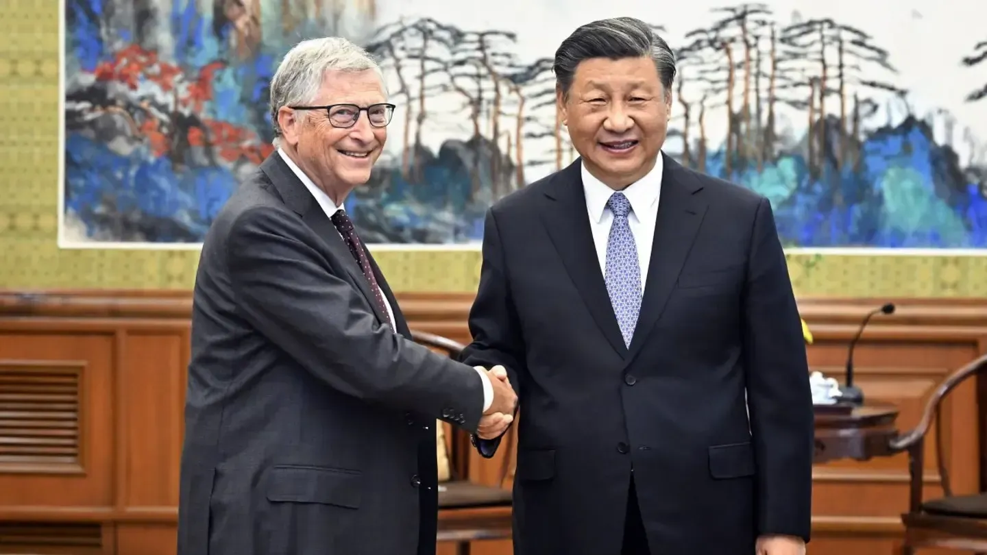 two men in suits shaking hands with friendly expressions
