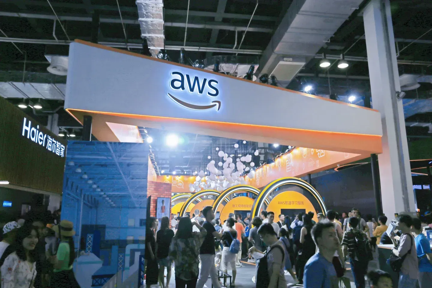 crowd of people passing by exhibition booth at trade show.