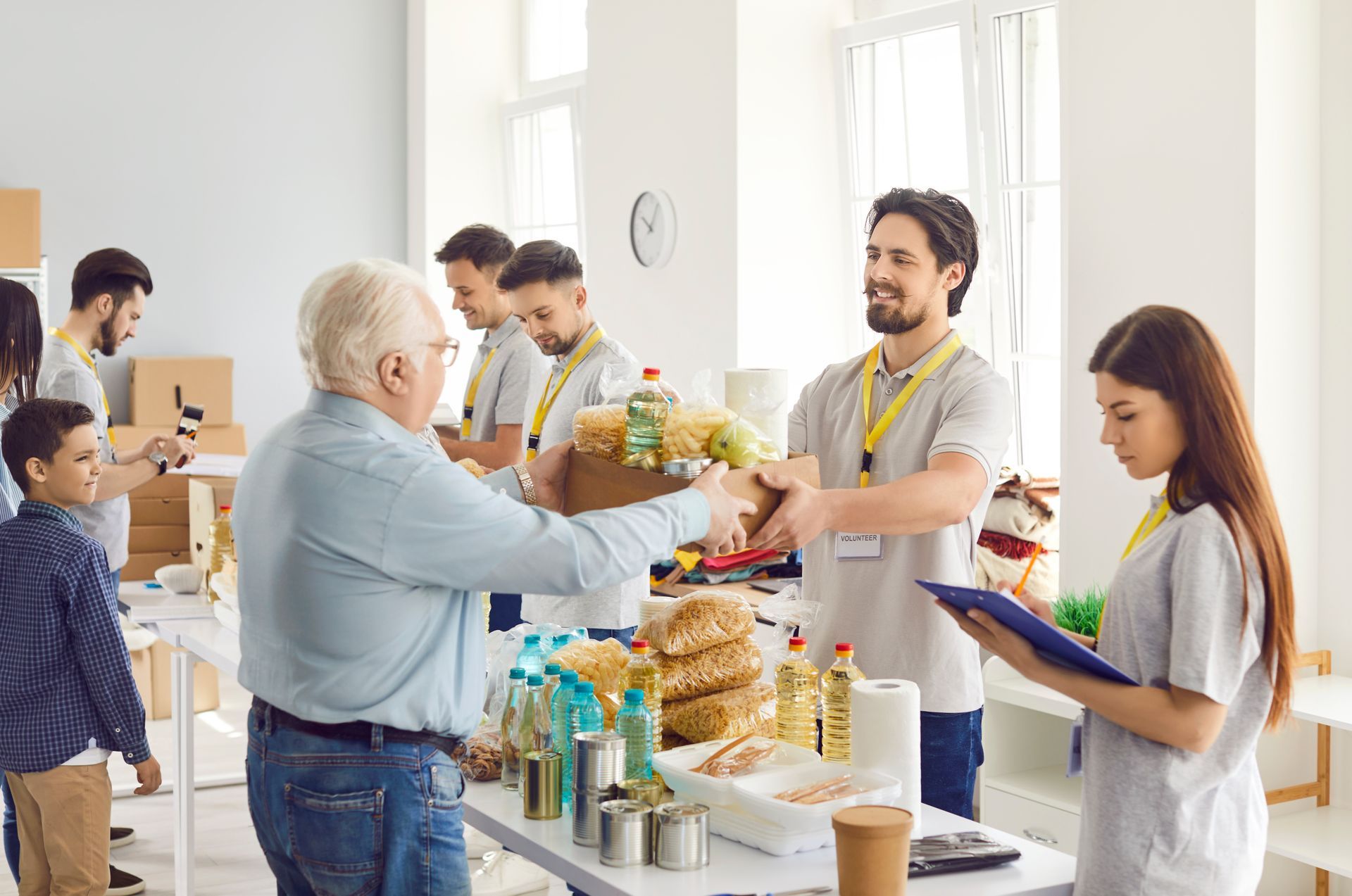 Volunteers distribute food boxes to people at a food bank.