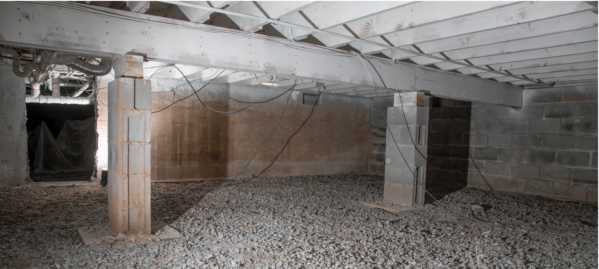 Crumbling basement crawlspace with exposed beams, concrete pillars, and debris on the floor.