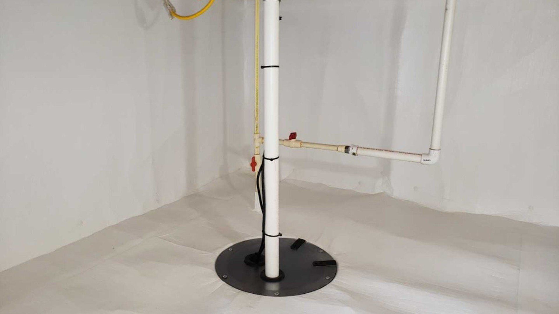 A white pole is sitting in the middle of a basement.