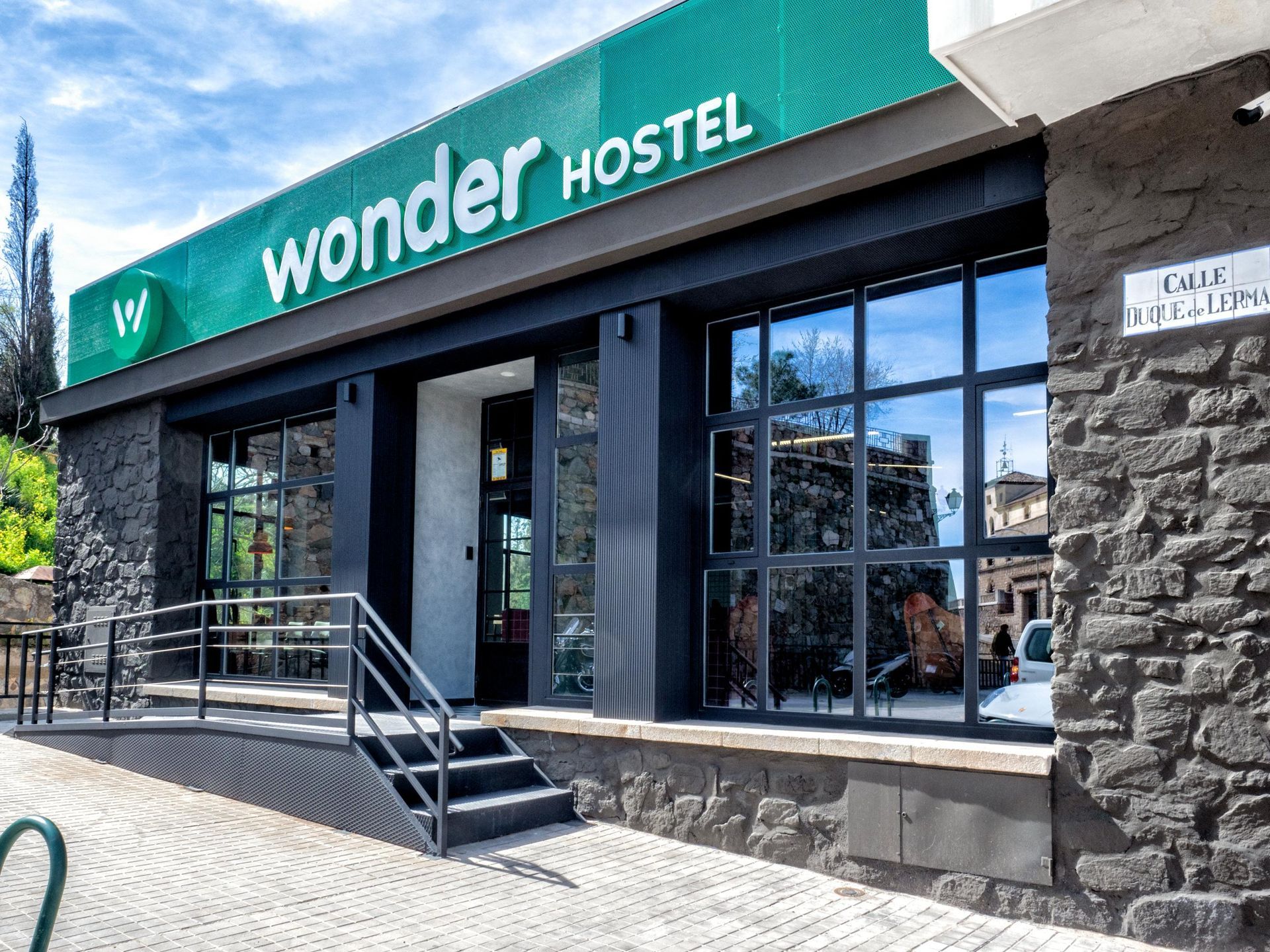 The front of a wonder hostel with stairs leading up to it.