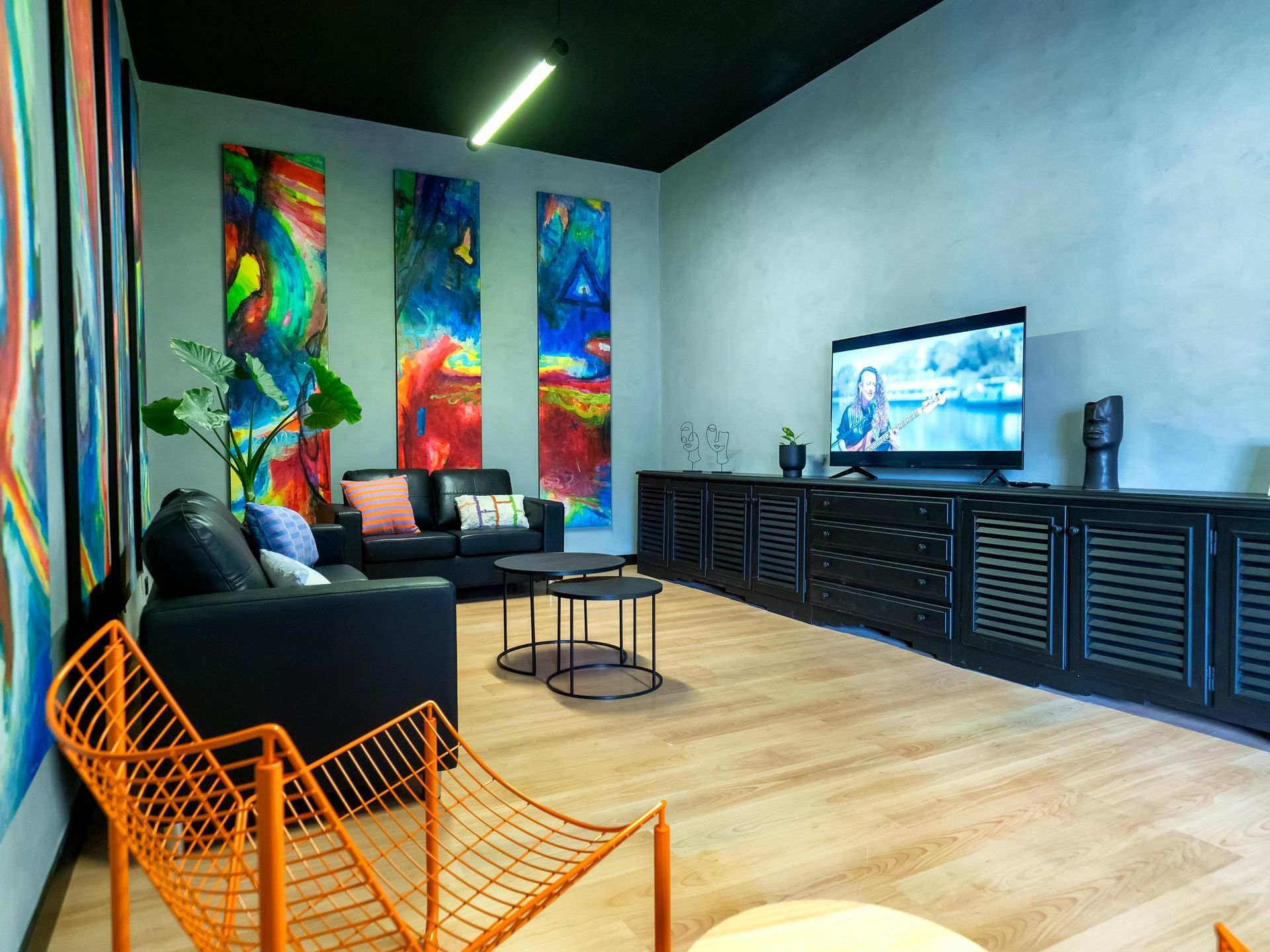 A living room with a couch , chair , table and television.