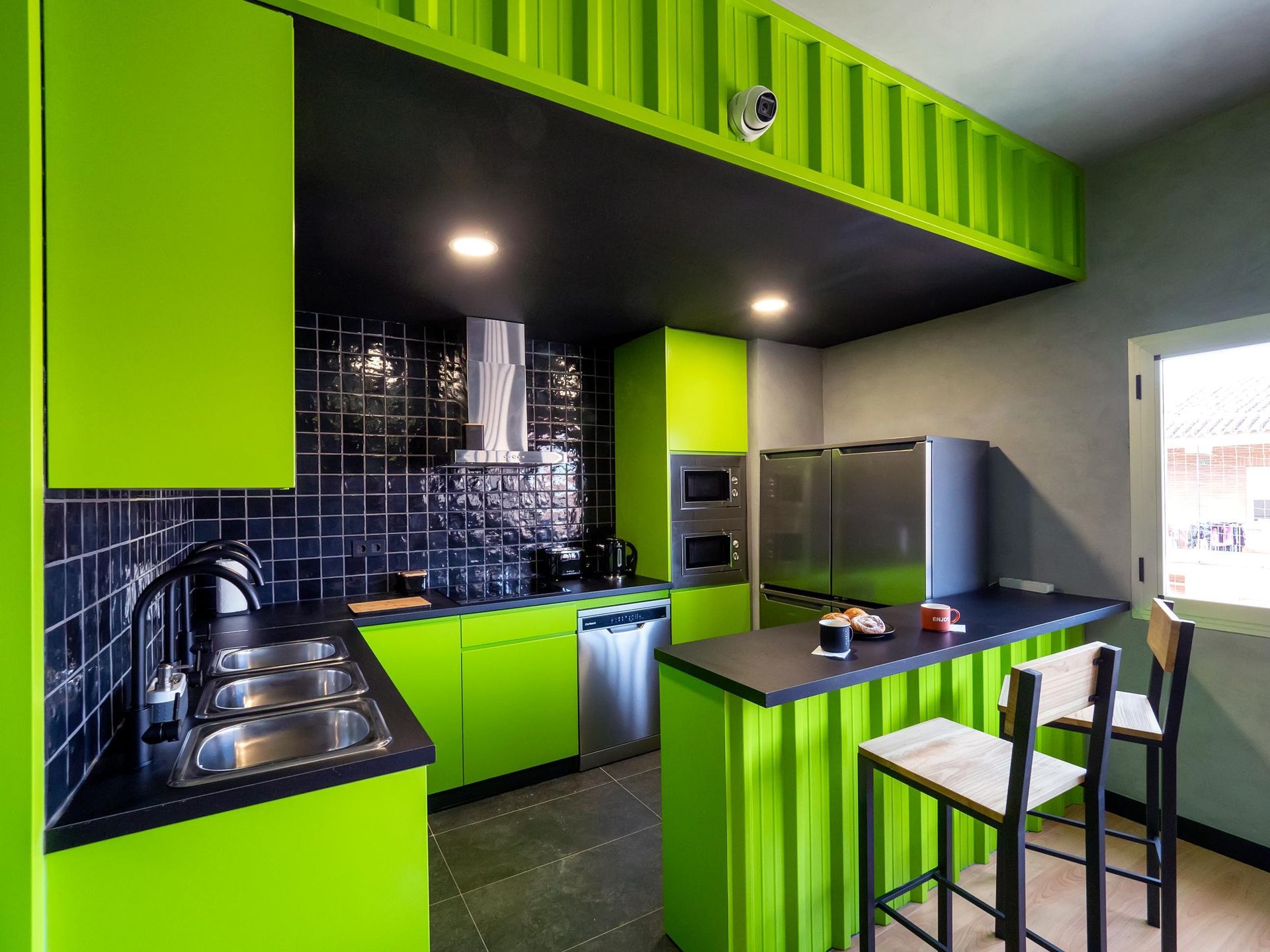 A kitchen with green cabinets and stainless steel appliances
