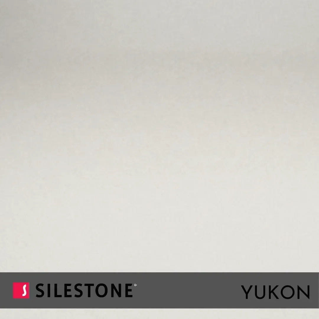 Muestra de Silestone Yukon con superficie color crema claro y etiqueta de marca negra en la parte inferior.