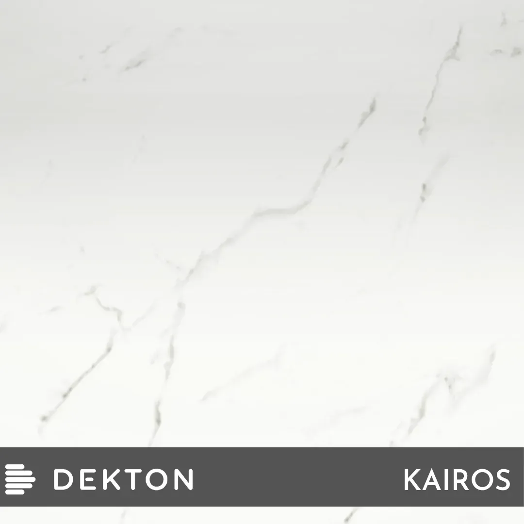 Superficie de mármol blanco con sutiles vetas grises, con la inscripción “DEKTON KAIROS” en la parte inferior.