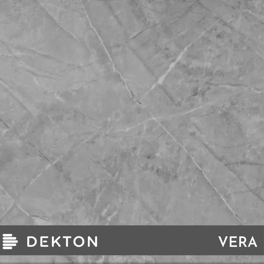 Muestra de azulejo gris con aspecto de mármol, con la etiqueta DEKTON y la marca VERA en la parte inferior.