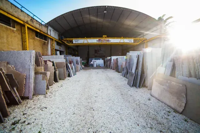 Losas de piedra expuestas en un pasillo de almacén con luz solar que entra desde la derecha.