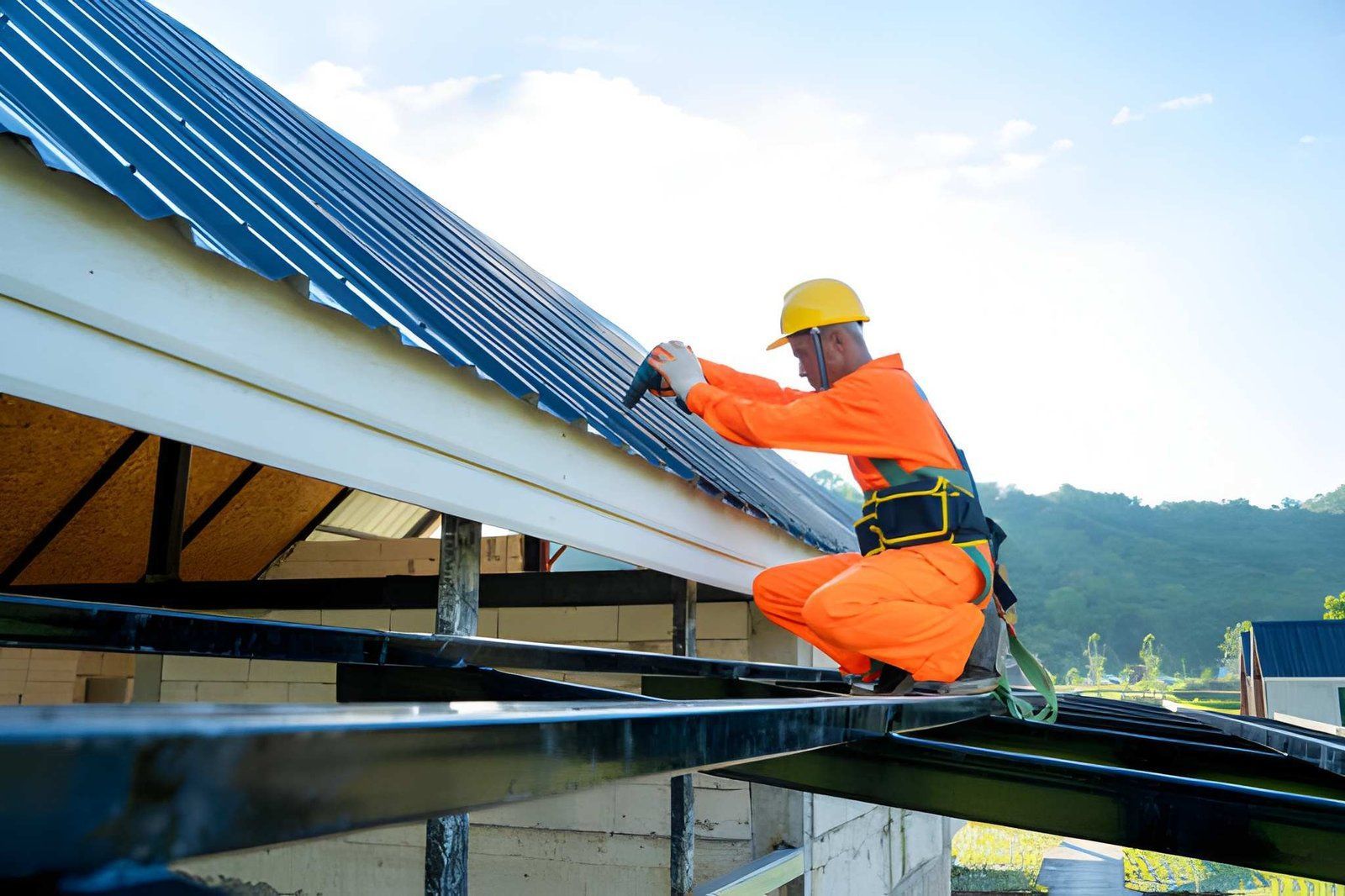 Worker in orange safety gear installing solar panels on a rooftop