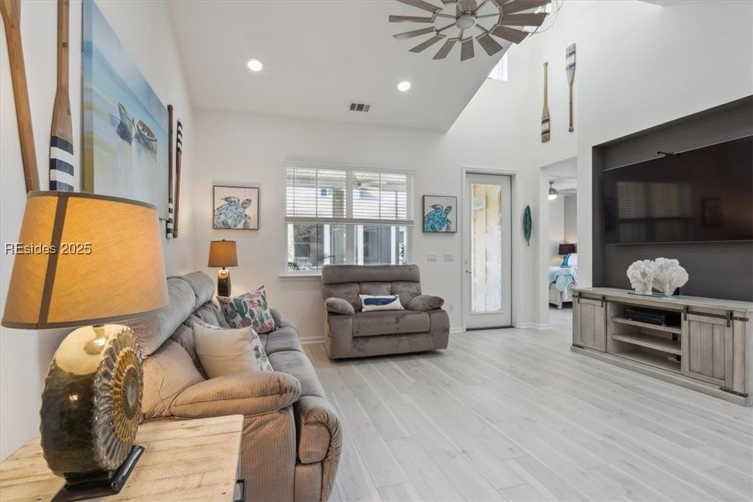 Bright coastal living room with white walls, light wood floor, and beachy decor.