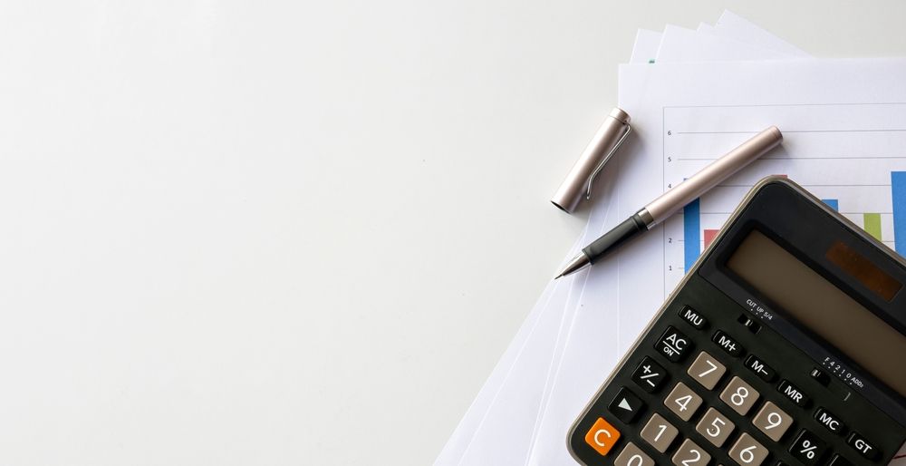 Calculator, pen, and financial charts on a white desk, illustrating financial analysis. — Sunshine Office Solutions in Mountain Creek, QLD
