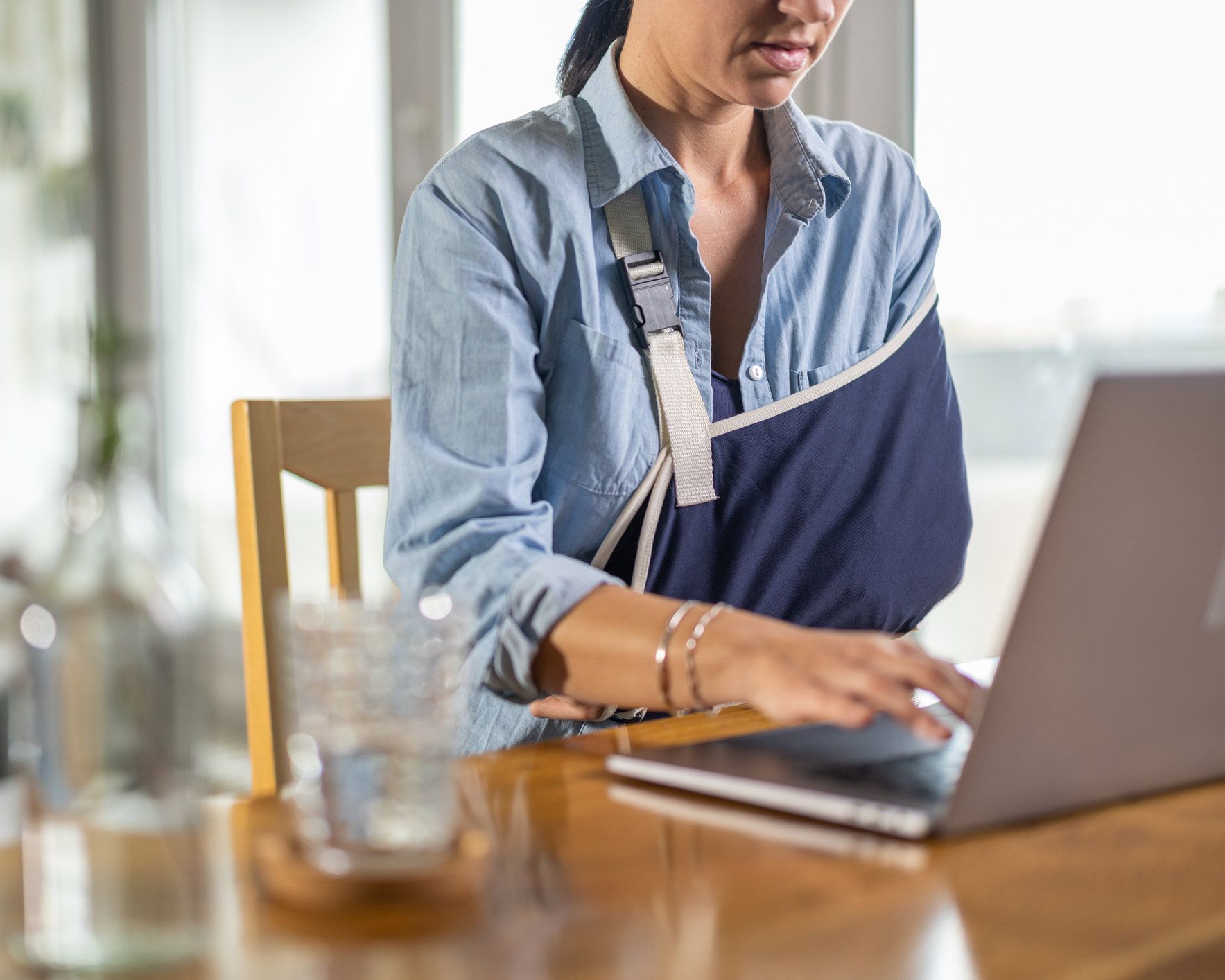 Woman with Injured Arm Working on Laptop | Fall River, MA | DGK Law