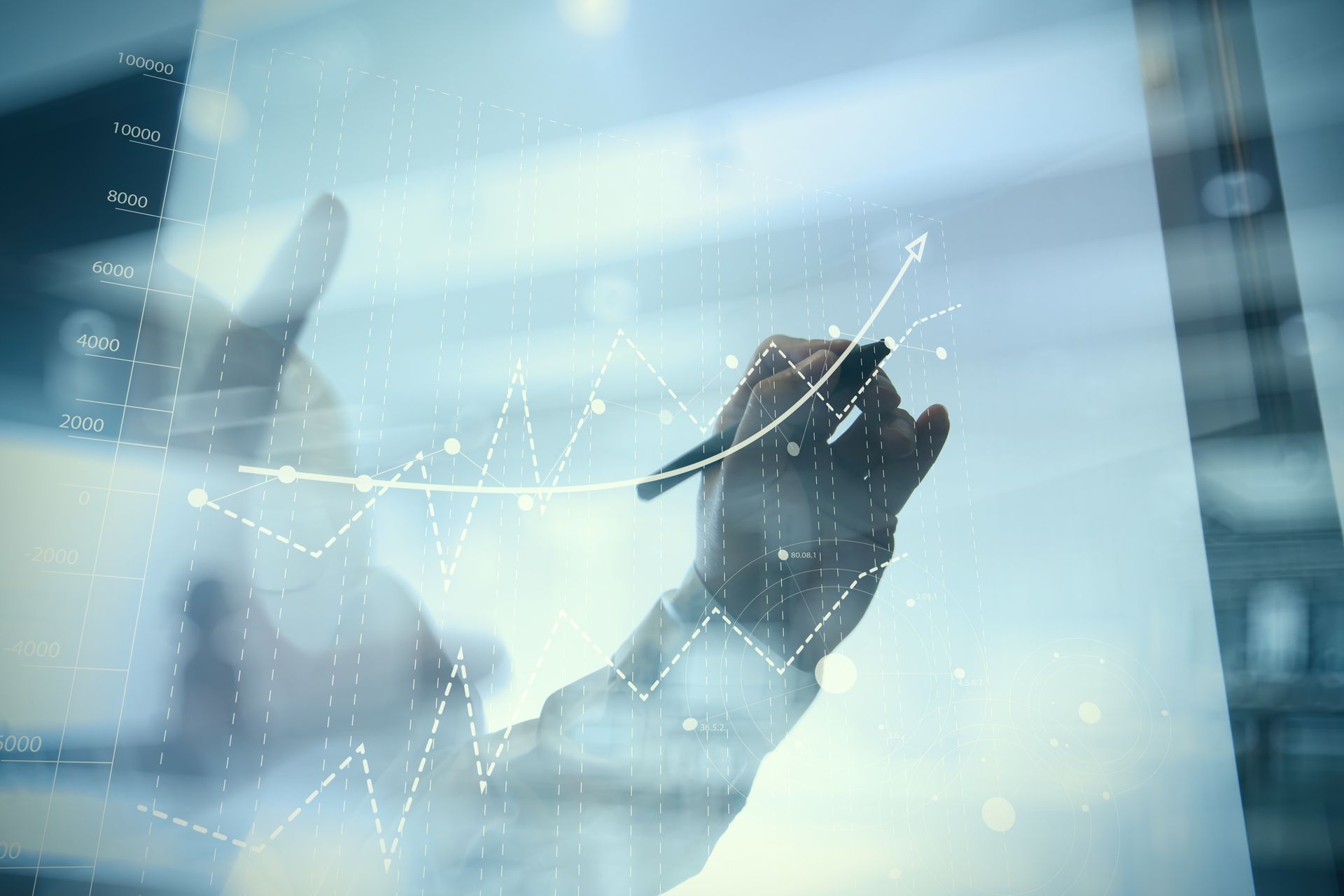 A person is drawing a graph on a glass wall with a pen.