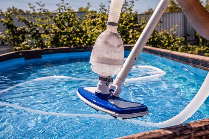 Pool vacuum cleaning blue water in an outdoor swimming pool