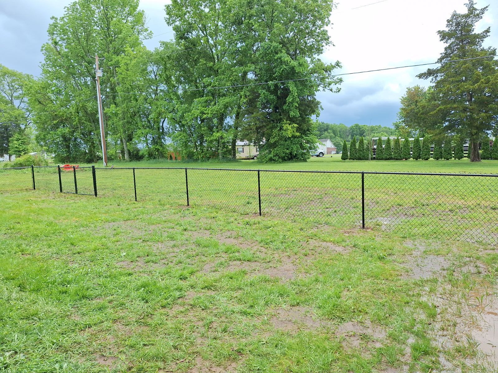 A lush green field with a fence and trees in the background. Clarksville, TN