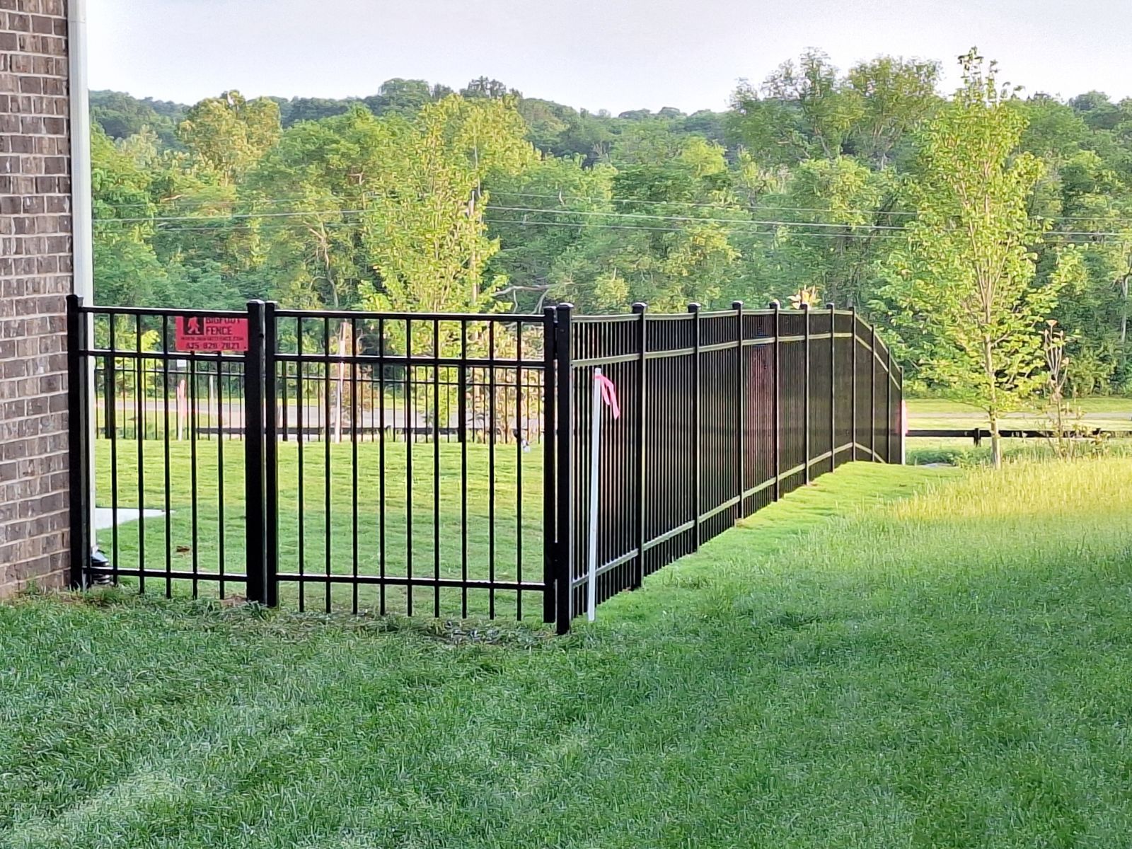 A black metal fence is surrounding a lush green field.Clarksville, TN