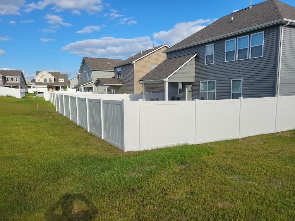 A white fence surrounds a grassy field in front of a house. Middle, TN