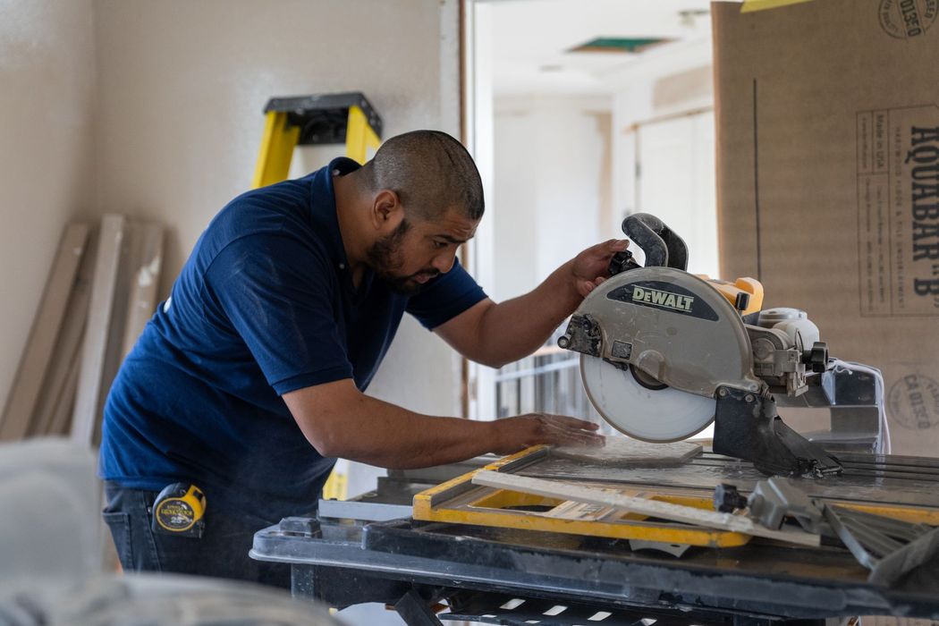 A man is cutting a piece of wood with a circular saw.