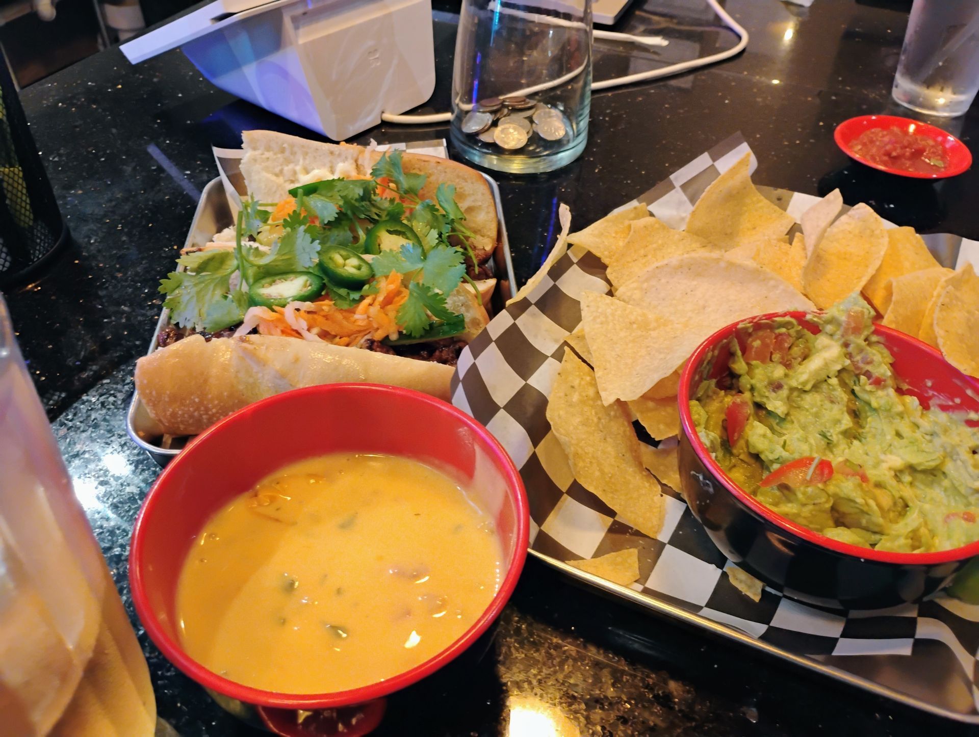 Mexican meal with guacamole, salsa, tortilla chips, and a taco salad on a restaurant table
