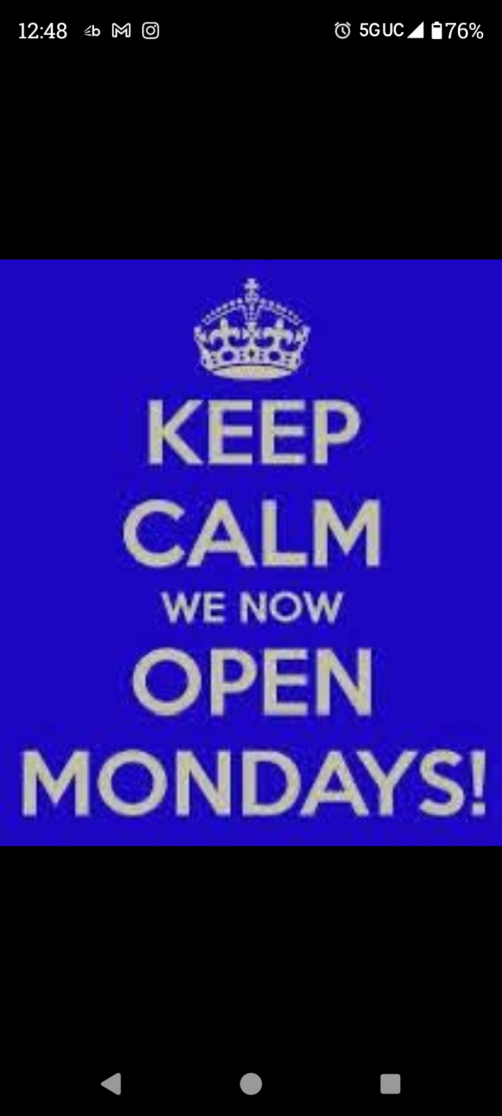 Blue sign with a crown icon reading “KEEP CALM WE NOW OPEN MONDAYS!”