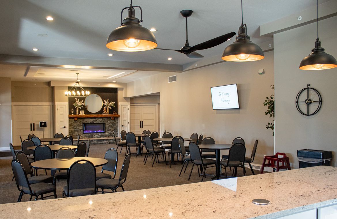 Empty dining room with tables, chairs, pendant lights, fireplace, and wall-mounted TV